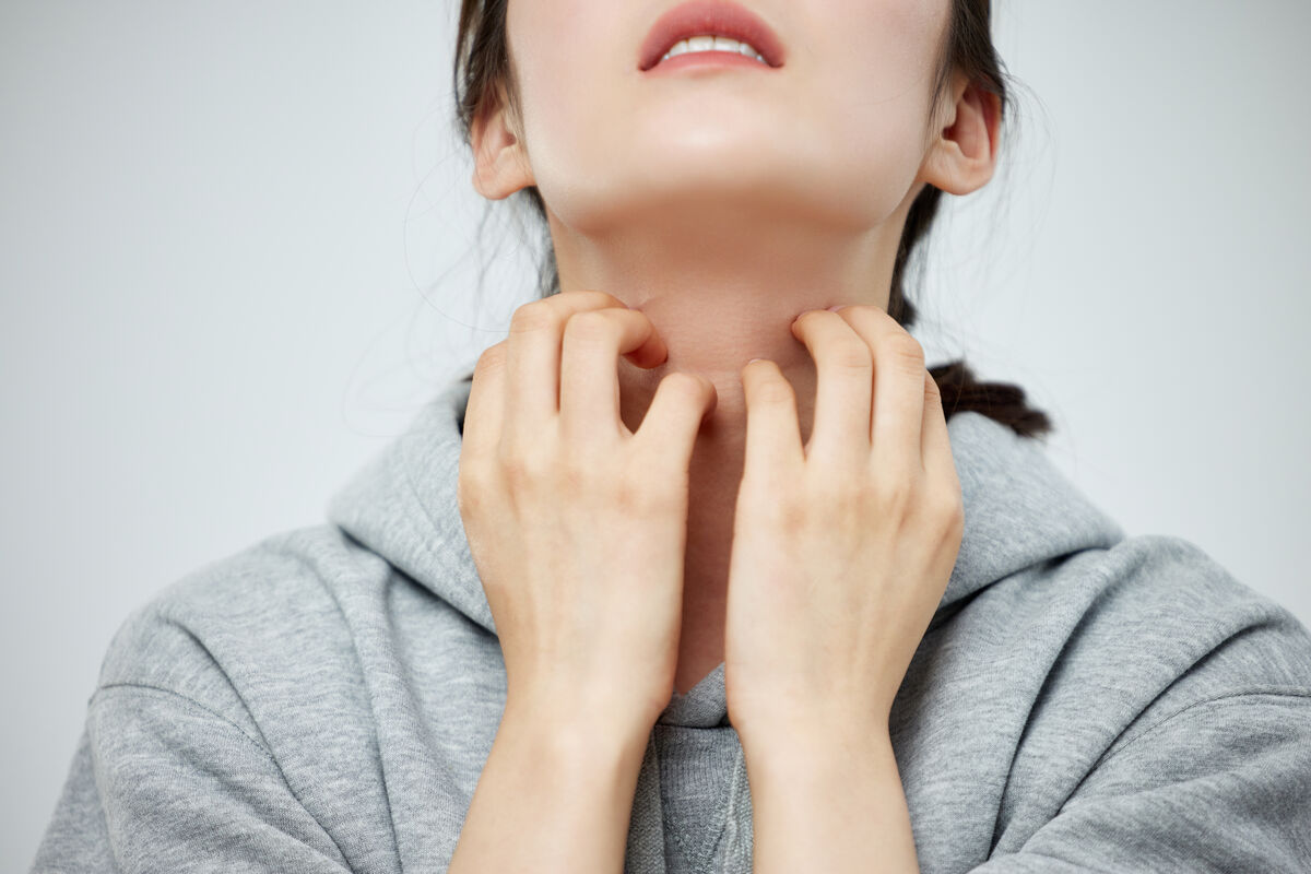Person scratching itchy skin on the neck caused by an eczema flare