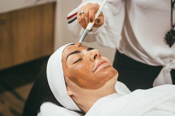 Woman receiving a professional facial treatment to address uneven skin tone and dark spots